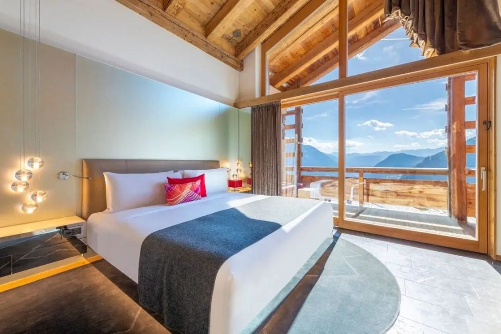 Luxus-Doppelzimmer mit Panoramafenster und alpinem Ausblick