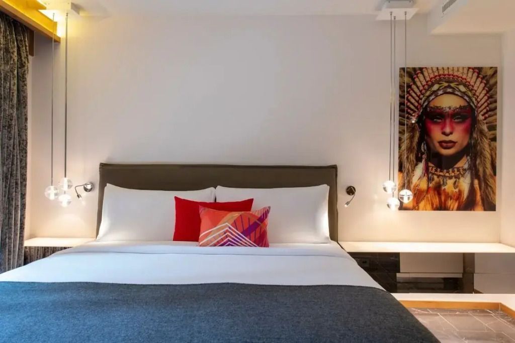 Modernes Schlafzimmer mit Kunstwerk an der Wand und stilvollen Nachttischlampen