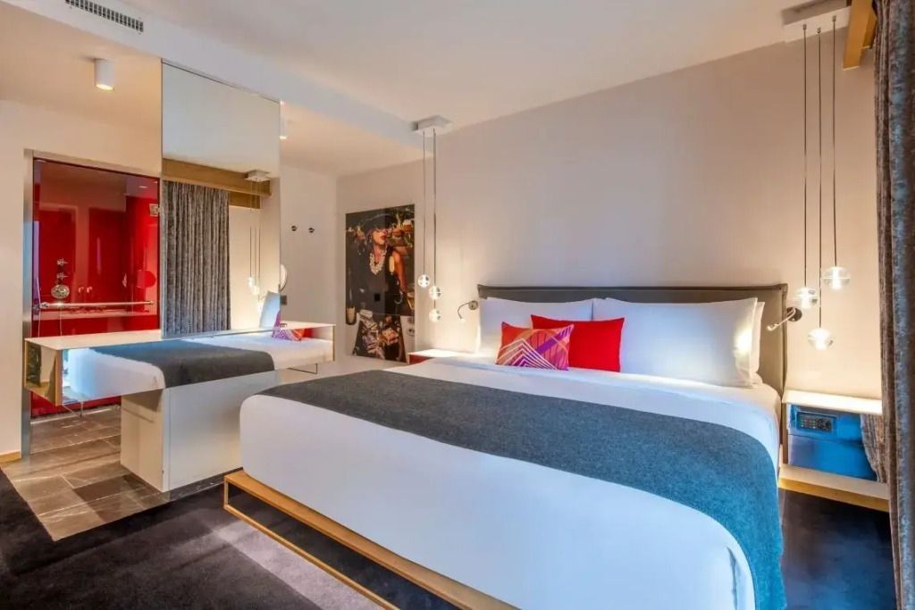 Helles Schlafzimmer mit Spiegel, dekorativen Kissen und Vorhängen