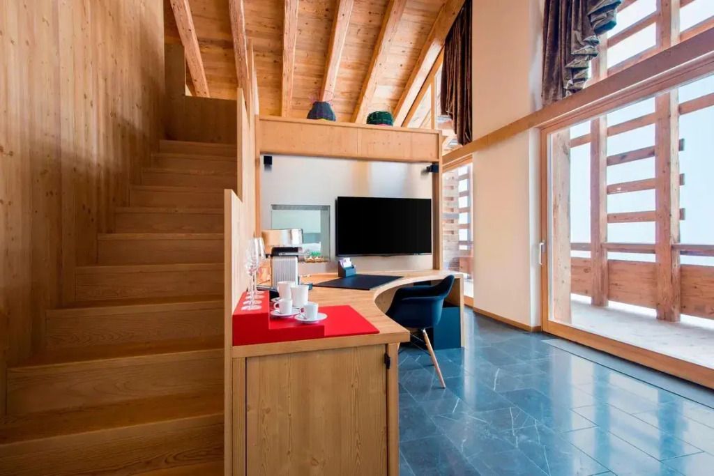 Treppenaufgang, Arbeitsbereich und Fernseher in elegantem Suite-Design