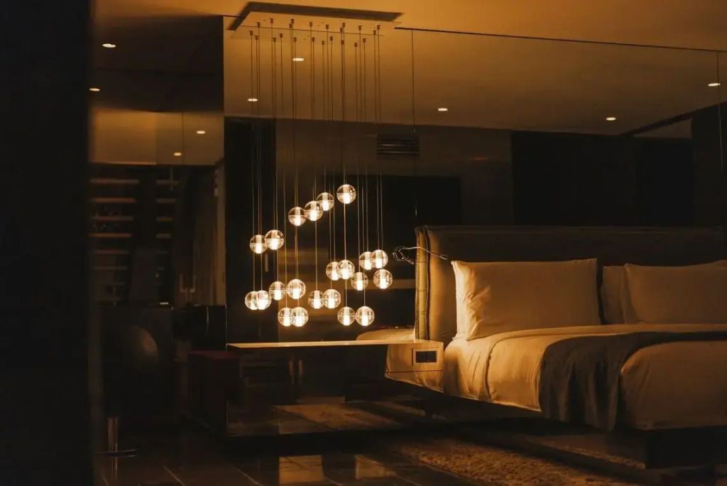 Gemütliches Schlafzimmer in der WOW Suite mit stilvollen hängenden Lampen und Spiegeln.