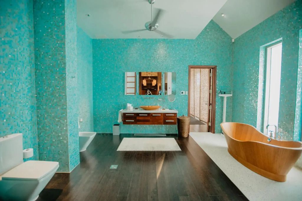 Helles Bad mit türkisfarbener Mosaikwand, moderner Badewanne und Doppelwaschbecken