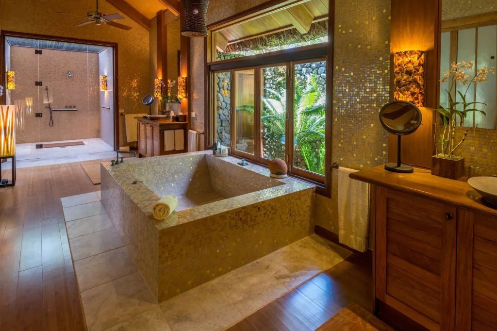 Luxuriöses Badezimmer mit freistehender Badewanne und Gartenblick