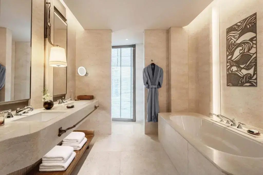 Großzügiges Badezimmer mit Badewanne und Bademantel