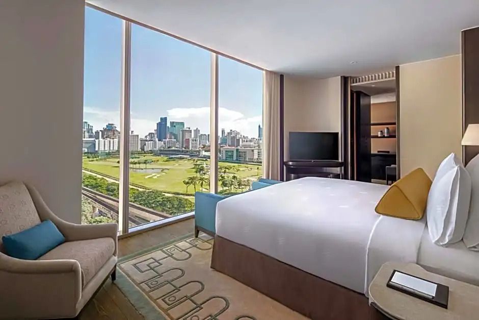 Geräumige Suite mit Doppelbett und Panoramablick auf die Stadt.