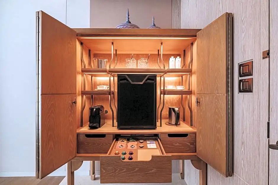 Offener Holzschrank mit Kaffeemaschine und Minibar.