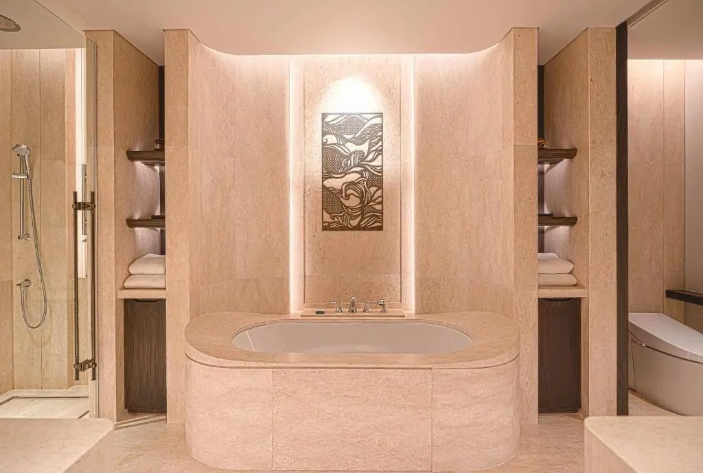 Luxuriöses Badezimmer mit großer freistehender Badewanne und kunstvoller Wanddekoration