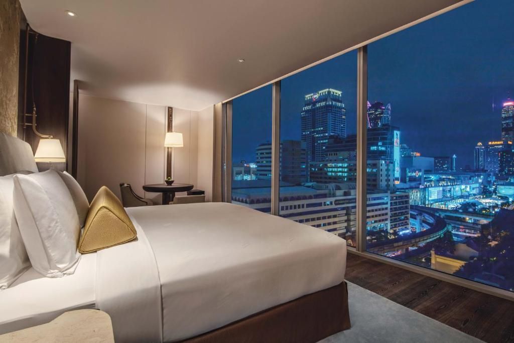 Luxuriöses Schlafzimmer mit Panoramablick auf die Stadt bei Nacht im Waldorf Astoria Bangkok