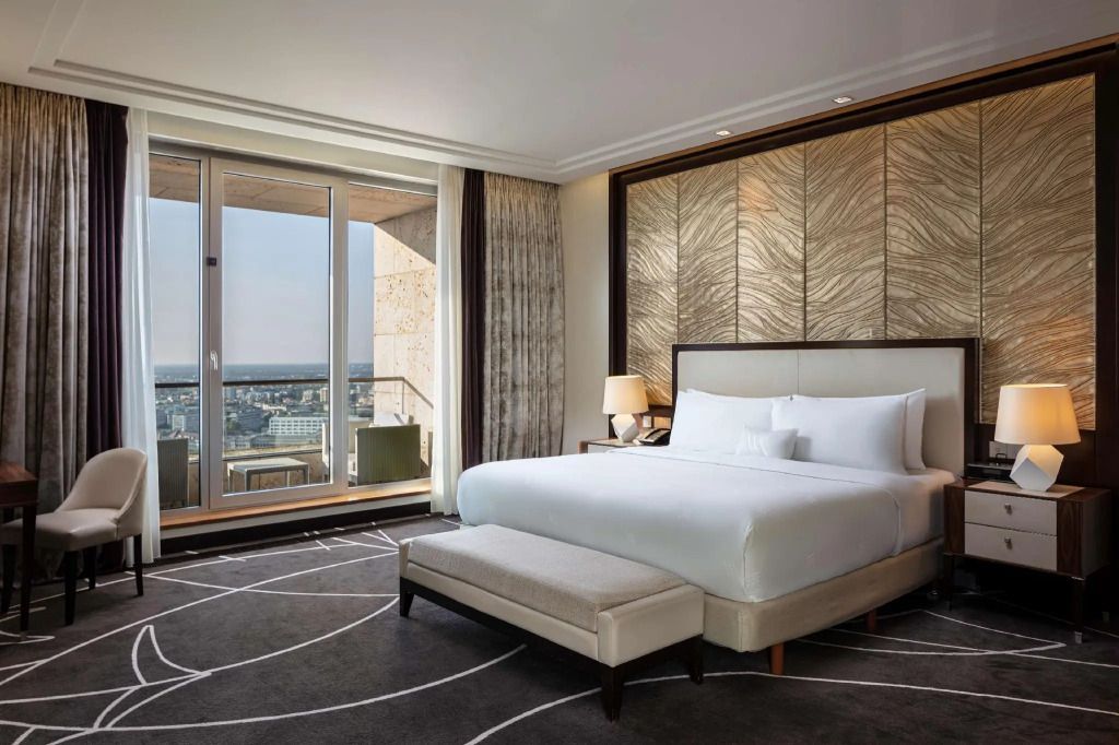 Geräumiges Schlafzimmer mit großem Bett und Blick auf die Stadt.