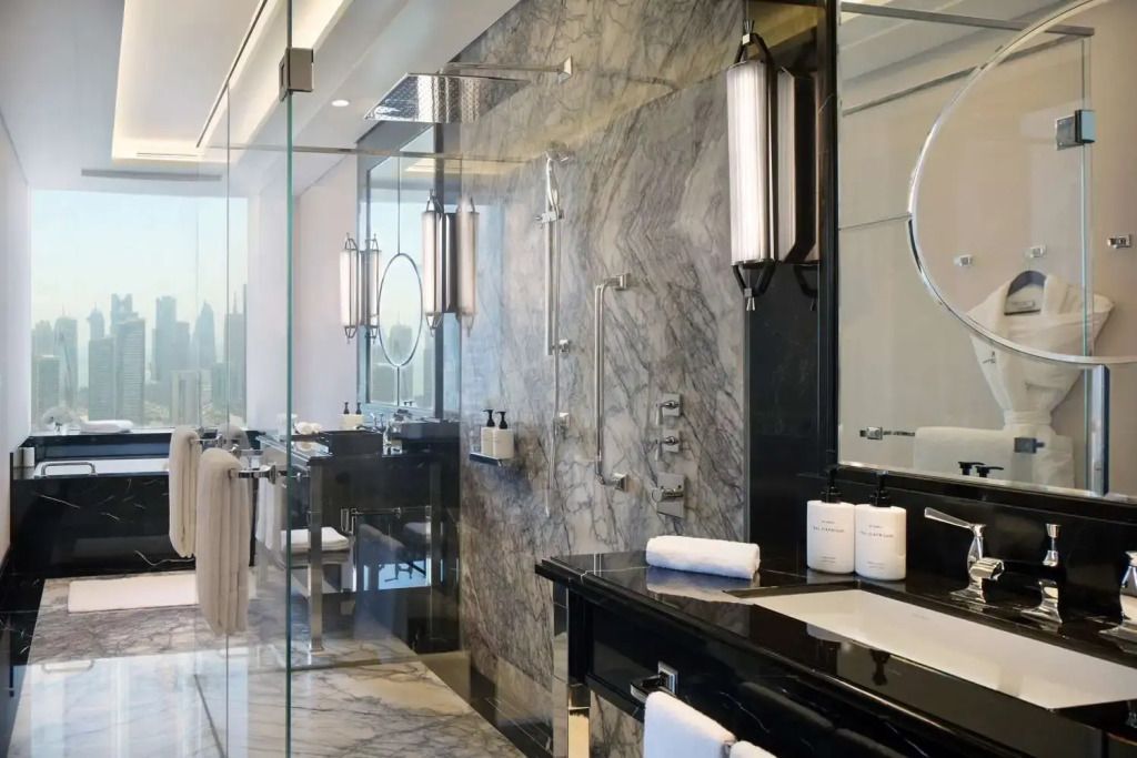 Luxuriöses Badezimmer mit Marmordetails und großer Spiegelwand in der Ambassador Suite.
