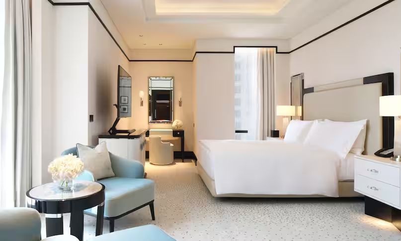 Geräumiges Hotelzimmer mit Schreibtisch, stilvollen Möbeln und großen Fenstern