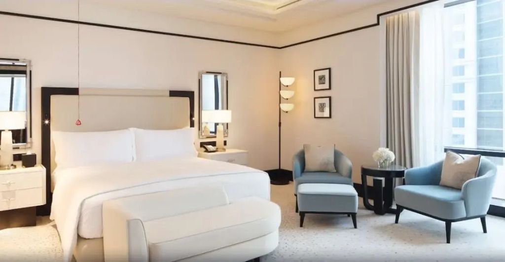 Elegantes Hotelzimmer mit Doppelbett, Sessel und stilvollem Dekor
