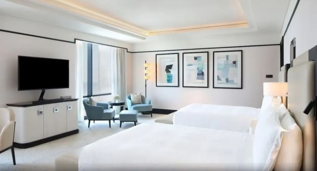 Luxuriöses Doppelzimmer mit Kunstwerken an der Wand und gemütlichen Sitzgelegenheiten