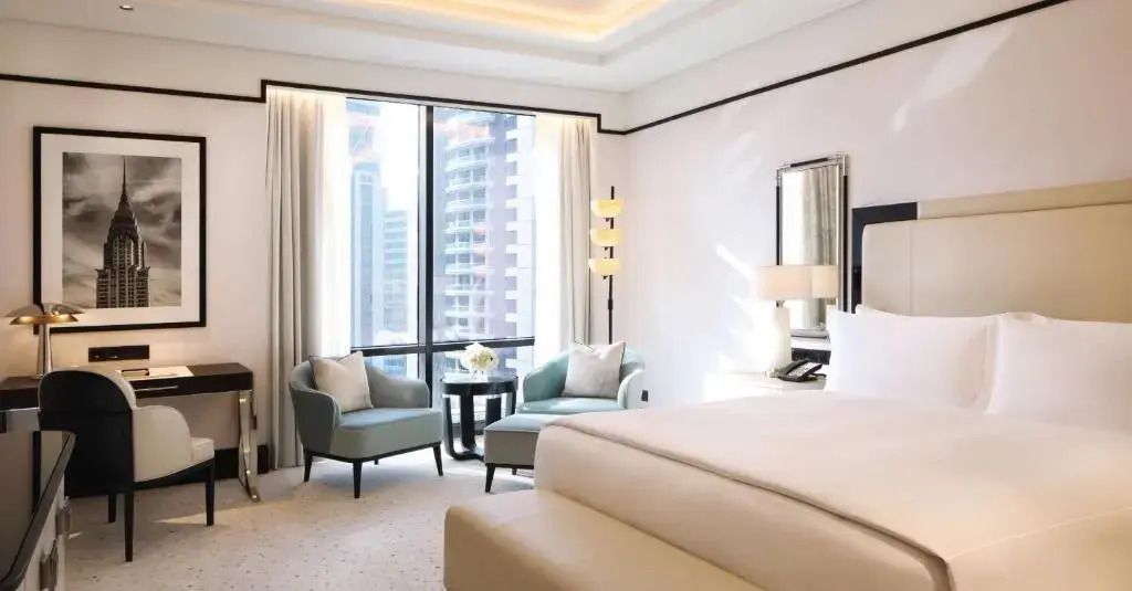 Helles Zimmer mit zwei Sesseln, großem Fenster und Stadtblick in der Präsidenten Suite