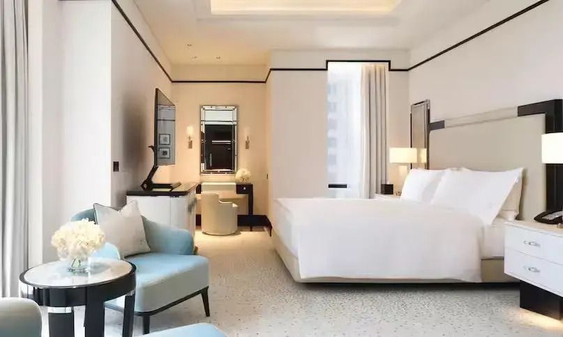 Helles und modernes Schlafzimmer der Royal Suite mit stilvoller Einrichtung und Sitzbereich.