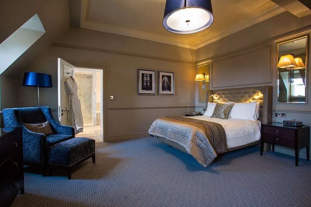 Elegante Suite mit Doppelbett, Sessel und Tageslichtbeleuchtung im Caledonian Edinburgh