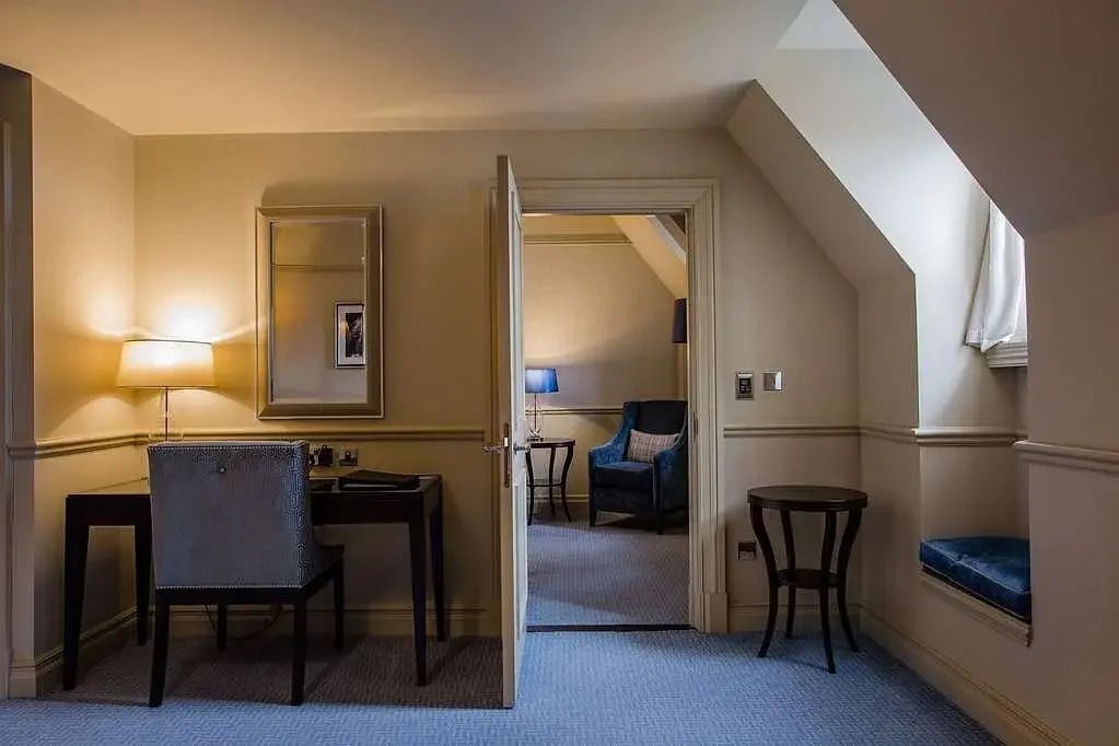 Luxuriöses Zimmer mit Schreibtisch, Sessel und natürlichem Licht im Hotel