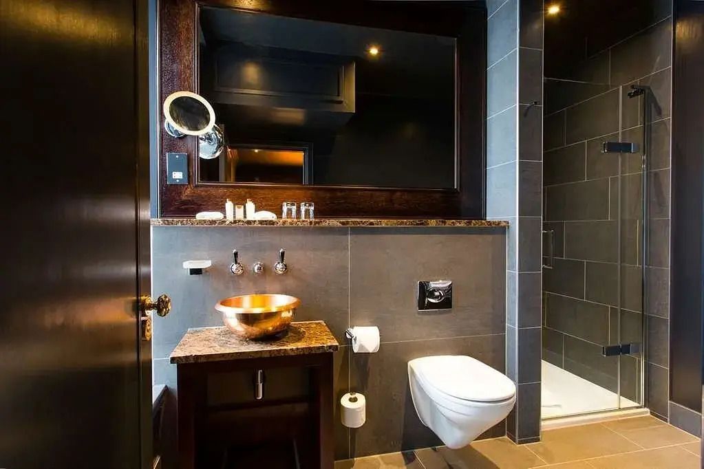 Modernes Badezimmer mit Waschtisch aus Kupfer und glatten Fliesen