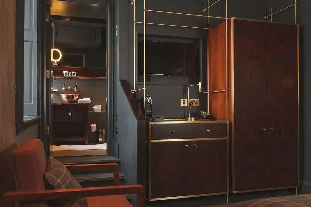Detailreiche Zimmereinrichtung mit dunklen Tönen und elegantem Schrank