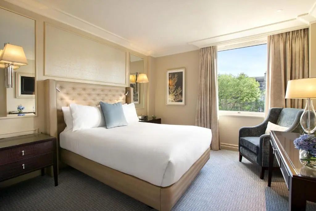 Helles Deluxe Doppelzimmer mit neutralen Tönen und Außensicht.