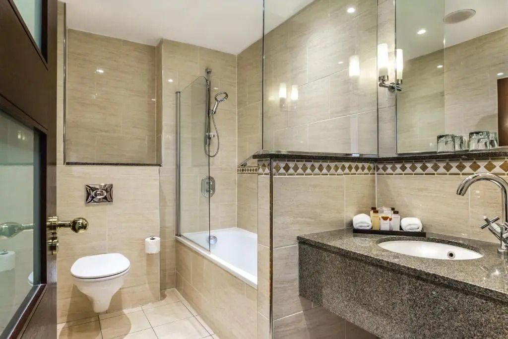 Modernes Badezimmer mit Badewanne und Spiegelwand.