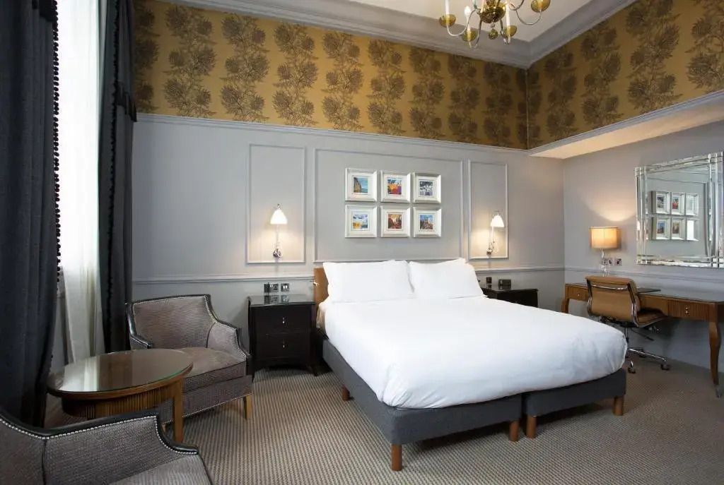 Elegantes Schlafzimmer mit Doppelbett und stilvollen Tapeten.