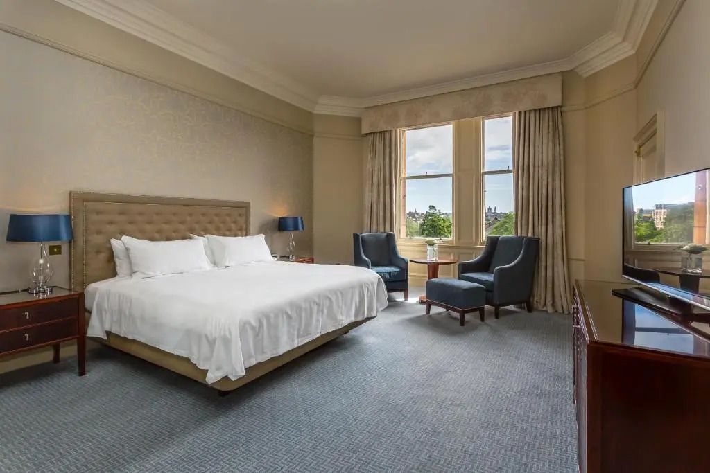 Helles Schlafzimmer mit großem Fenster und Blick auf die Natur.