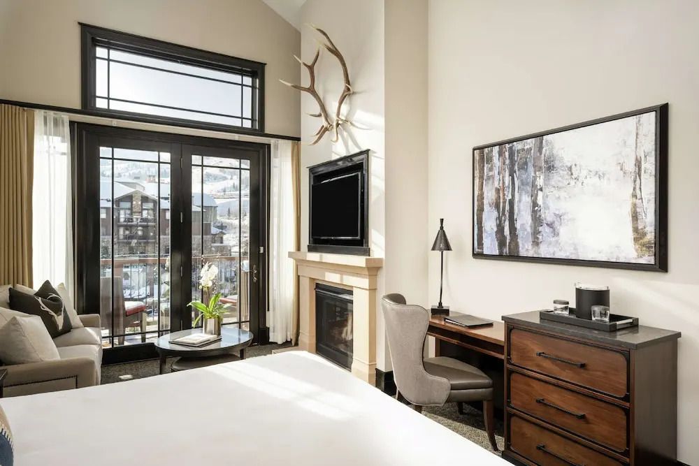 Junior-Suite mit Kamin, Schreibtisch und Balkonfenstern