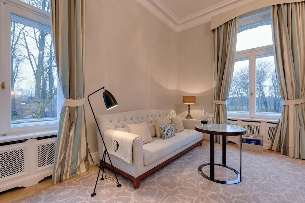 Gemütliche Sitzecke im Zimmer mit Sofa, Stehlampe und großem Fenster