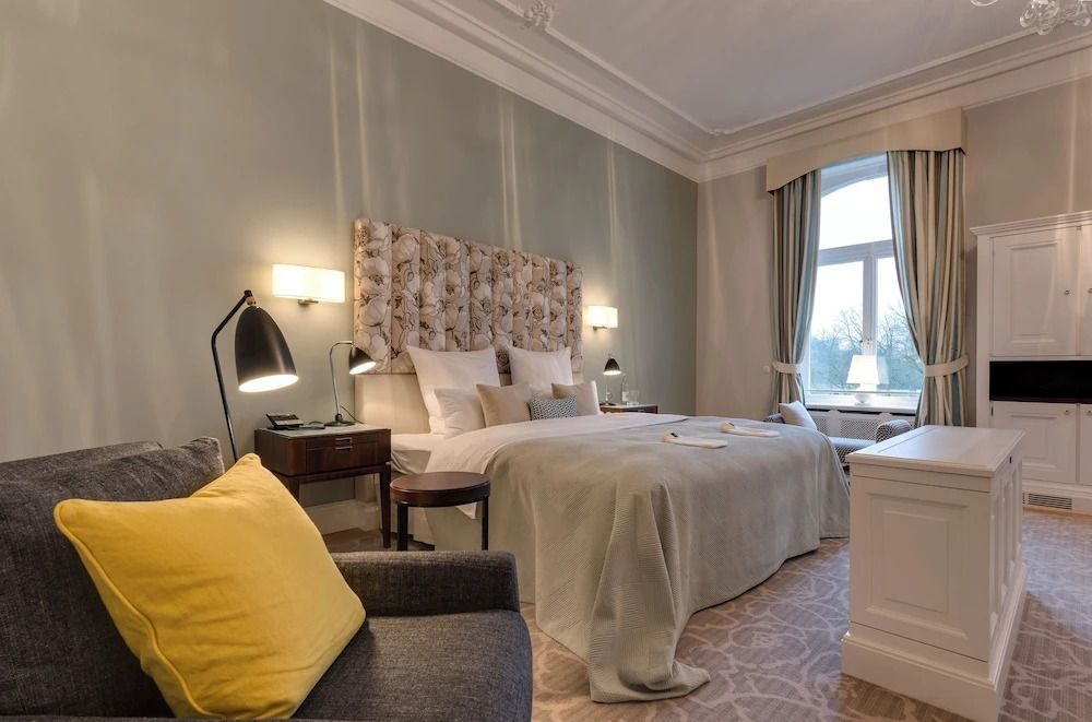 Geräumiges Zimmer mit großem Bett, eleganten Vorhängen und klassischer Einrichtung