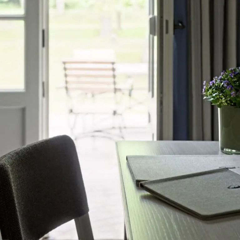 Helles Zimmer mit Blick auf Terrasse und stilvollem Arbeitstisch