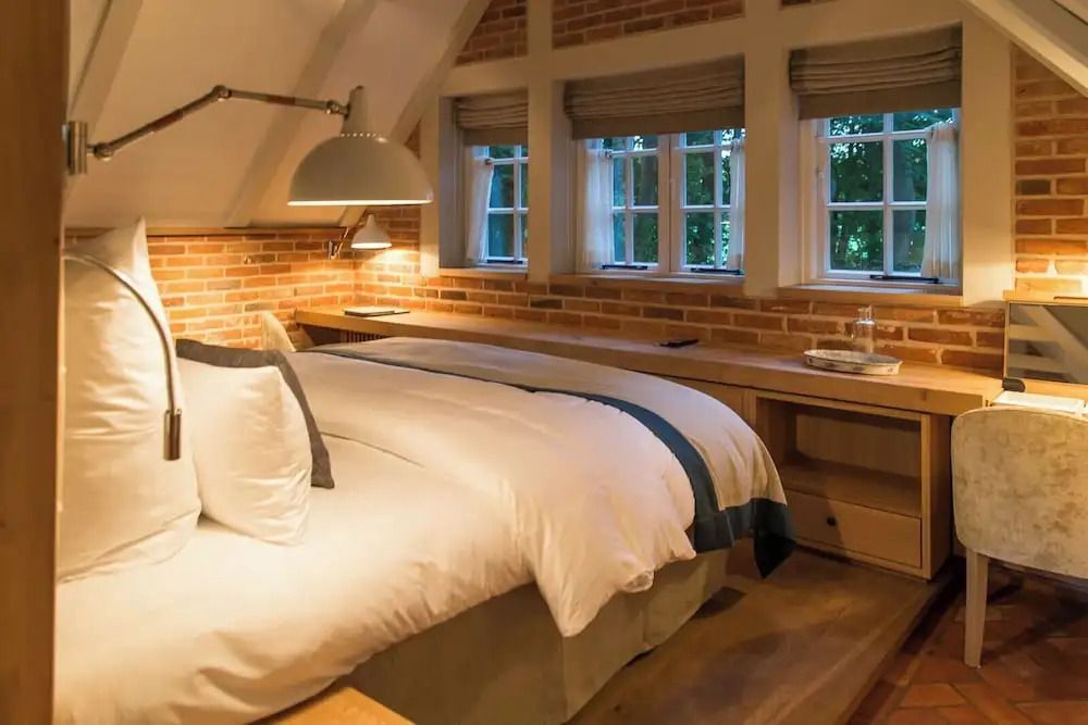 Gemütliches Schlafzimmer mit Ziegelwänden und Dachschrägen