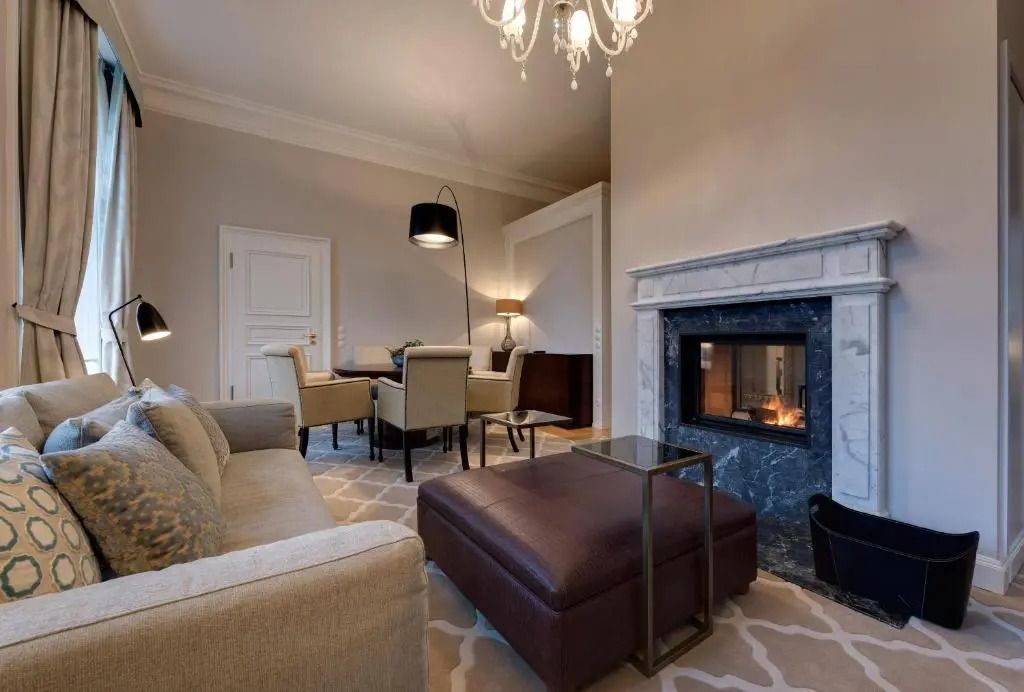 Eleganter Wohnbereich einer Suite mit Kamin und gemütlicher Sitzecke