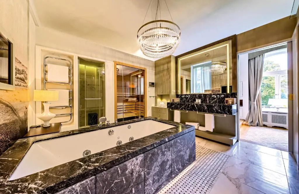 Luxuriöses Badezimmer mit großer Badewanne und Kristallleuchter