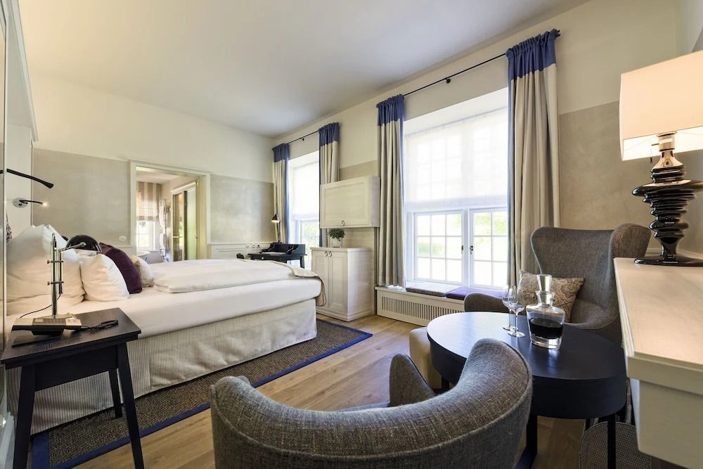 Helles Superior Zimmer mit großem Bett und Sitzbereich im Weissenhaus Resort