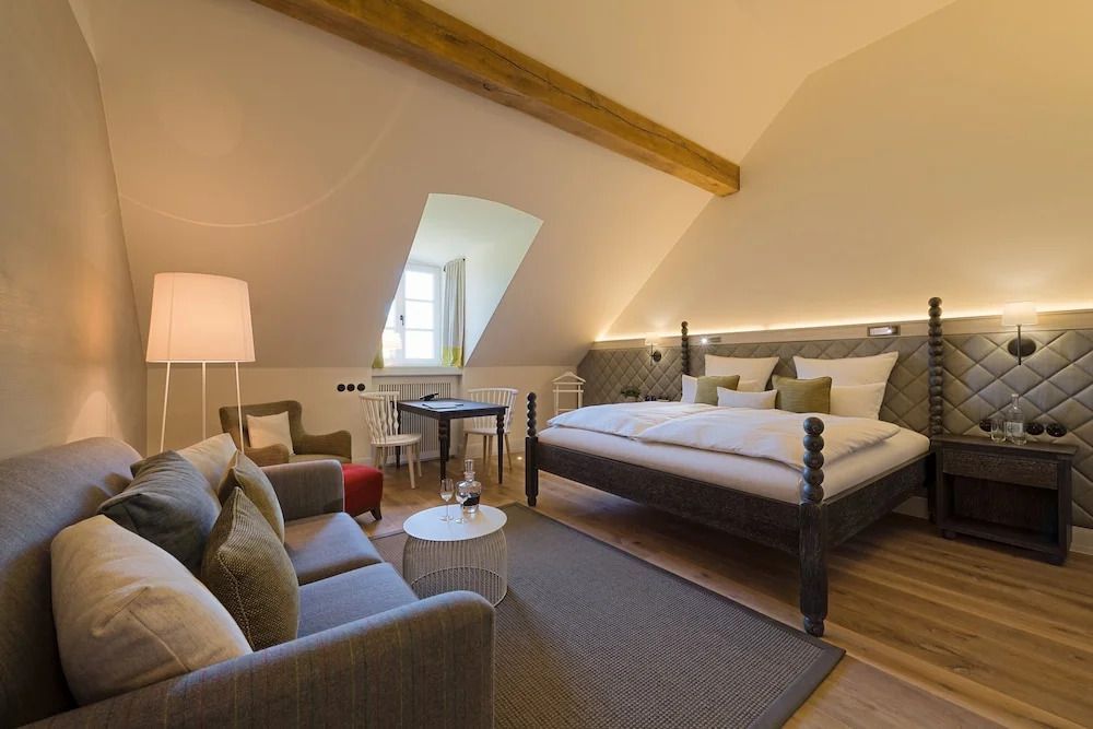 Gemütliche Sitzecke und großes Bett in einem Superior Zimmer mit Dachschräge