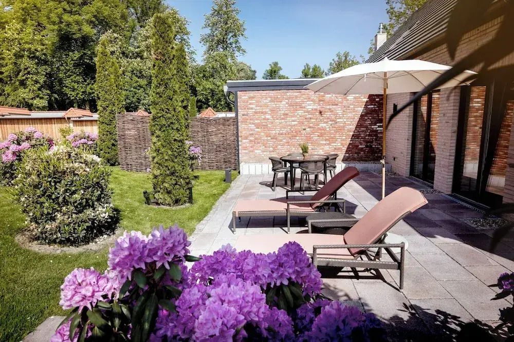 Sonnige Hotelterrasse mit Liegestühlen und blühenden Pflanzen