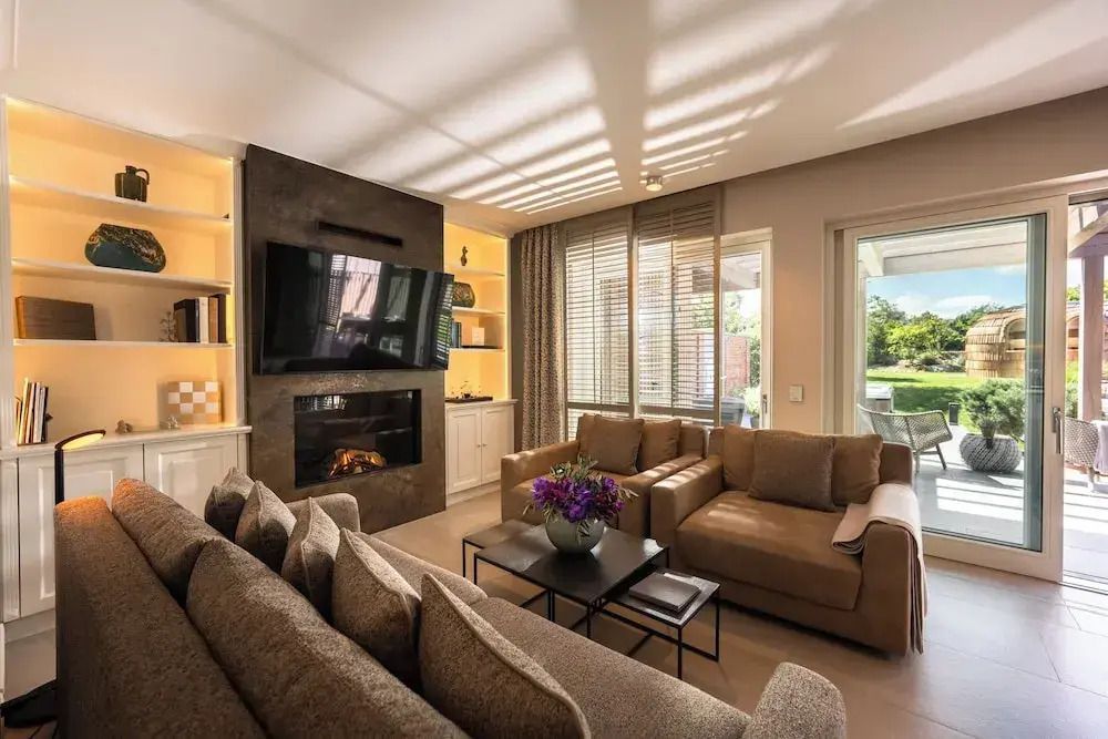 Luxuriöses Wohnzimmer mit Kamin und großen Sofas im Hotelresort