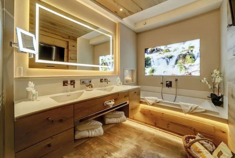Modernes Badezimmer mit großem Spiegel und Badewanne in der Deluxe Suite