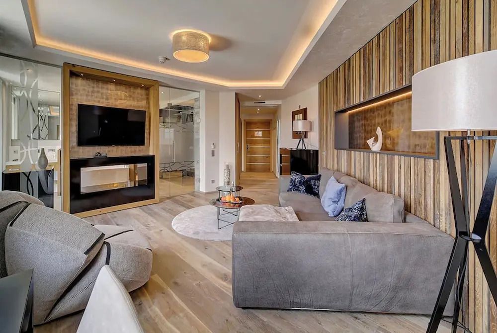 Luxuriöses Wohnzimmer mit TV und komfortablen Sitzgelegenheiten
