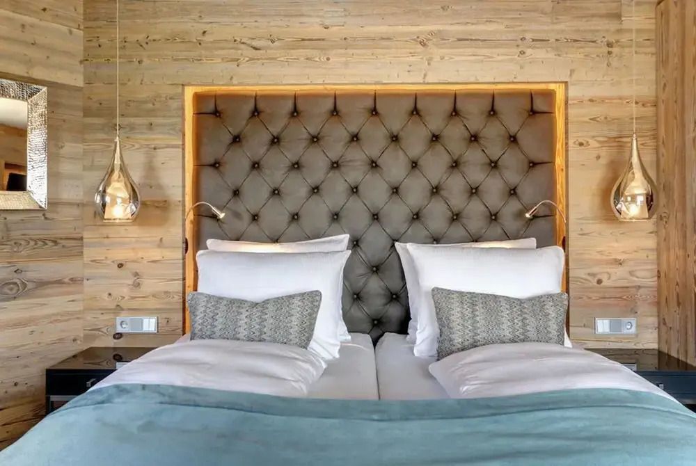 Luxuriöses Schlafzimmer mit aufwendig gepolstertem Kopfteil und Holzverkleidung