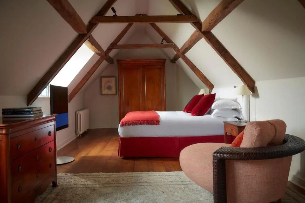 Luxuriöses Schlafzimmer mit Holzbalkendecke in der Deluxe Suite
