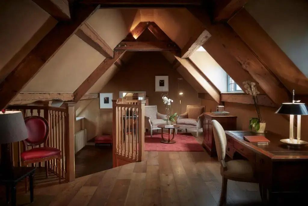 Gemütlicher Wohnbereich mit Sesseln und Holzdecke in der Deluxe Suite
