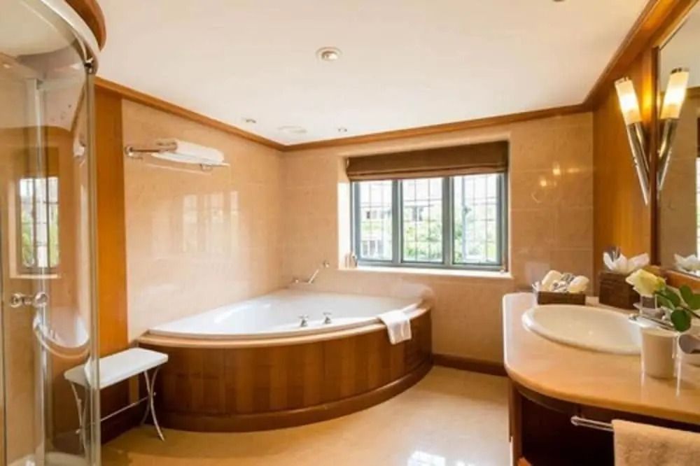 Elegantes Badezimmer mit großer Badewanne und Fenster.