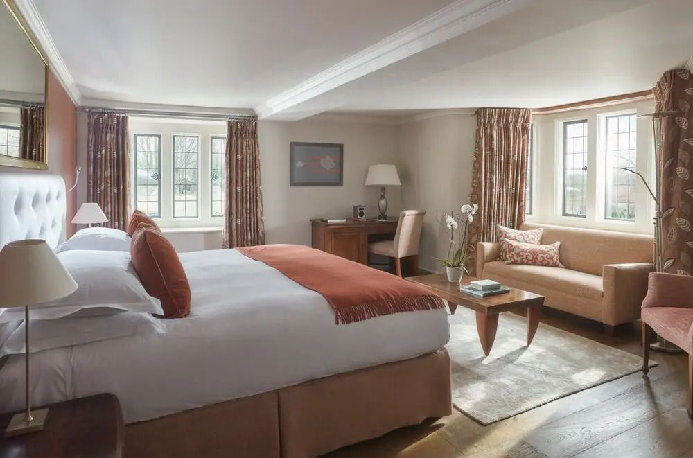 Helle Junior-Suite mit großem Bett und gemütlichem Sitzbereich.