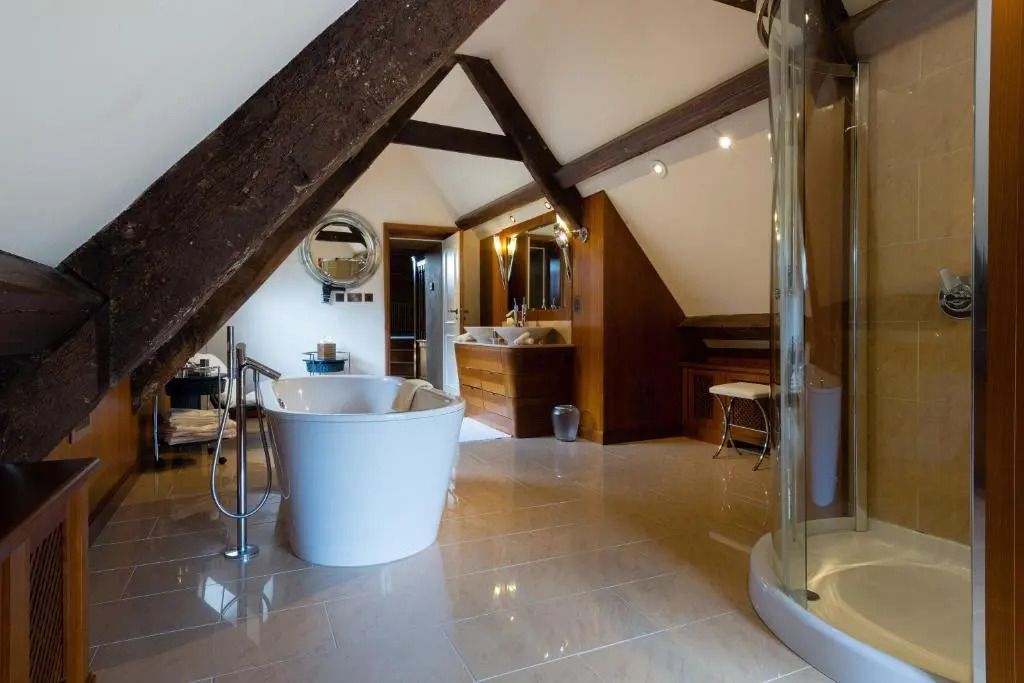 Luxuriöses Badezimmer mit freistehender Badewanne und Holzdetails