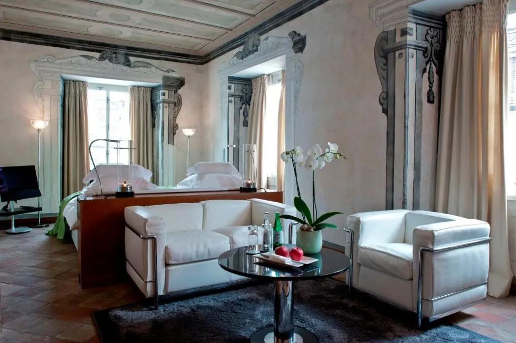 Luxuriöses Doppelzimmer mit Designer-Sesseln und kunstvoller Wanddekoration