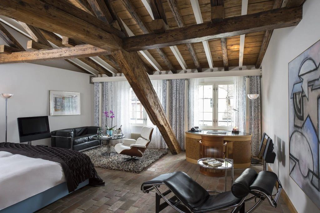 Geräumiges Zimmer im Dachgeschoss mit Holzbalken und stilvollen Möbeln