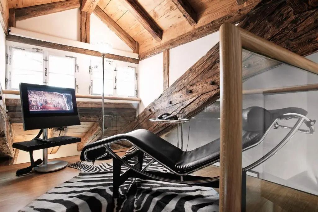 Designer-Liege in modernem Zimmer mit schräger Holzdecke