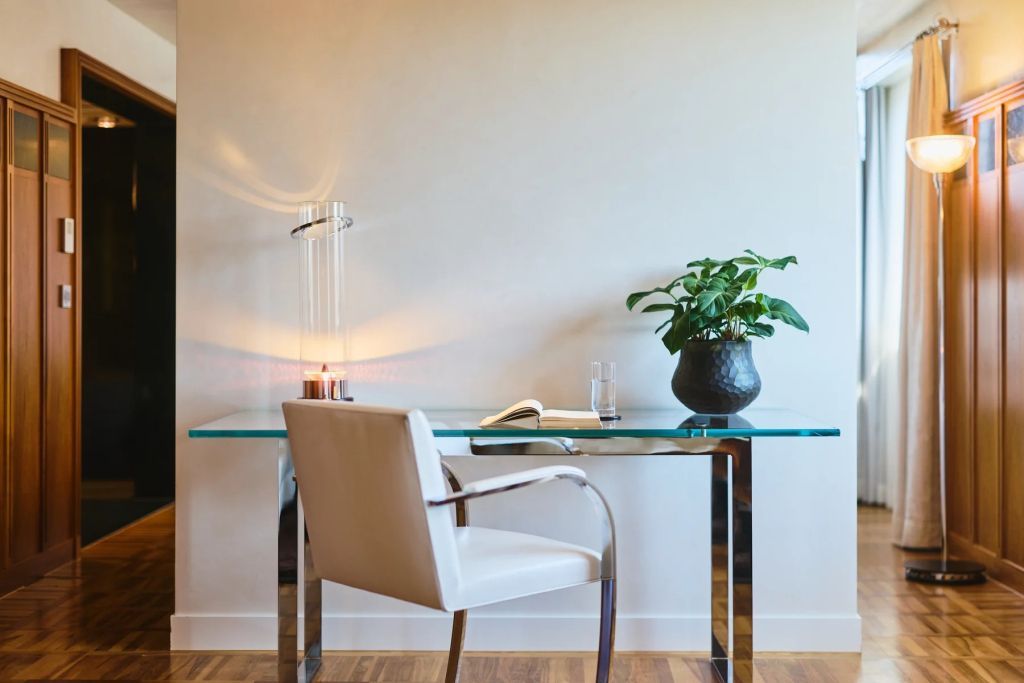 Eleganter Arbeitsbereich mit Glas-Schreibtisch und Dekoration